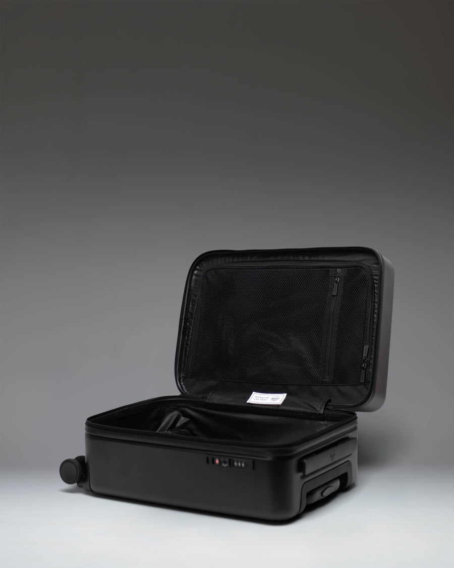 Herschel Heritage Hardshell Carry On Luggage in black, shown from the side to highlight its durable exterior and sleek design.