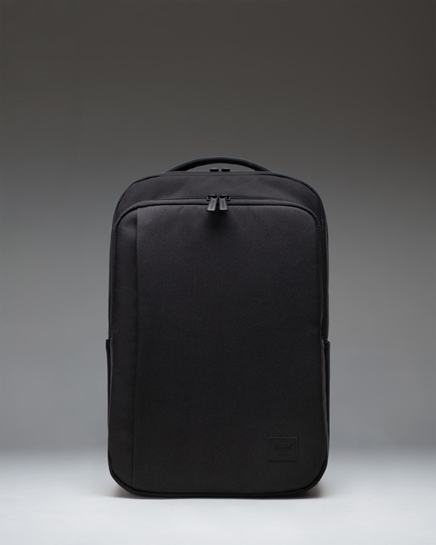 Black Herschel Supply Co. Kaslo Daypack Tech backpack viewed from the front, showcasing its clean design, dual top handles, and zippered pockets.