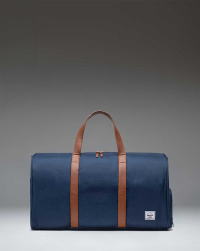 Navy blue Herschel Novel Duffle bag with two top carrying handles and a shoulder strap.