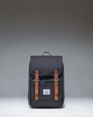 Herschel Retreat Mini Backpack in Black. Front view showcasing its classic design with a top handle, single strap closure, and front storage sleeve.