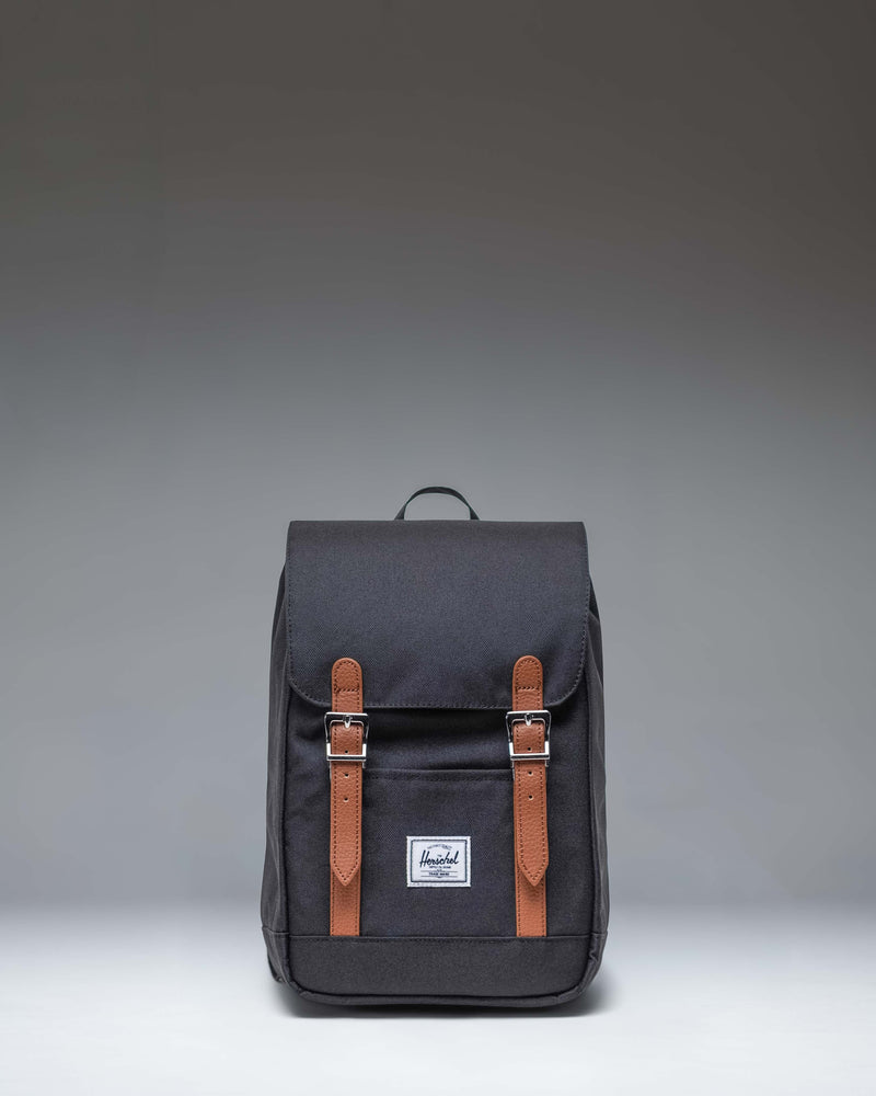 Herschel Retreat Mini Backpack in Black. Front view showcasing its classic design with a top handle, single strap closure, and front storage sleeve.