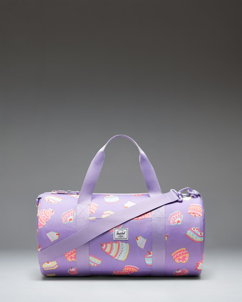 Herschel Classic Duffle Little Herschel in Cakes colorway, a pink kids' duffle bag featuring a colorful cake pattern.