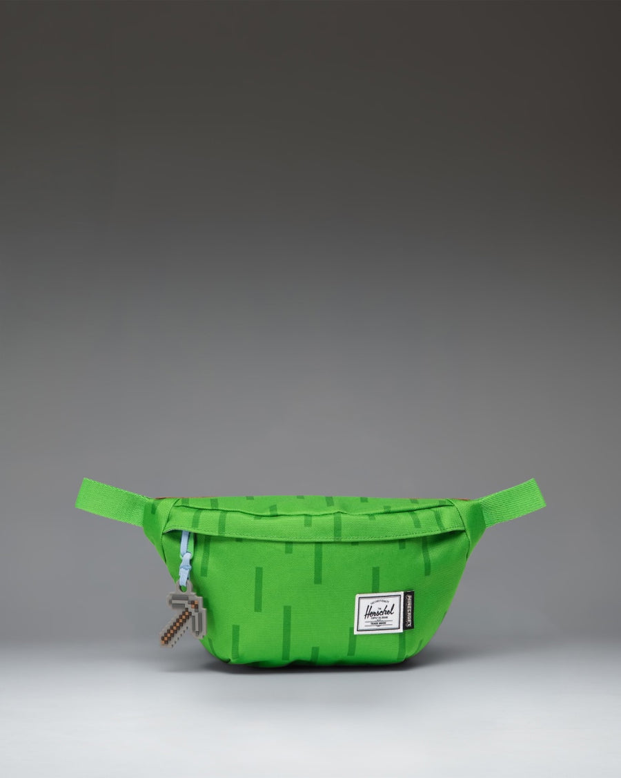 Herschel Supply Co. Minecraft Classic Hip Pack in The Overworld print, featuring a pixelated green and blue landscape design.
