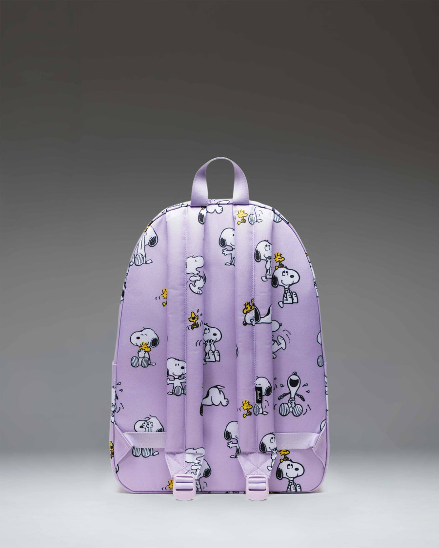 Herschel Supply Co. Peanuts Classic XL Backpack in Snoopy and Woodstock Pastel Lilac showing front pocket, main zipper, and side water bottle pocket.