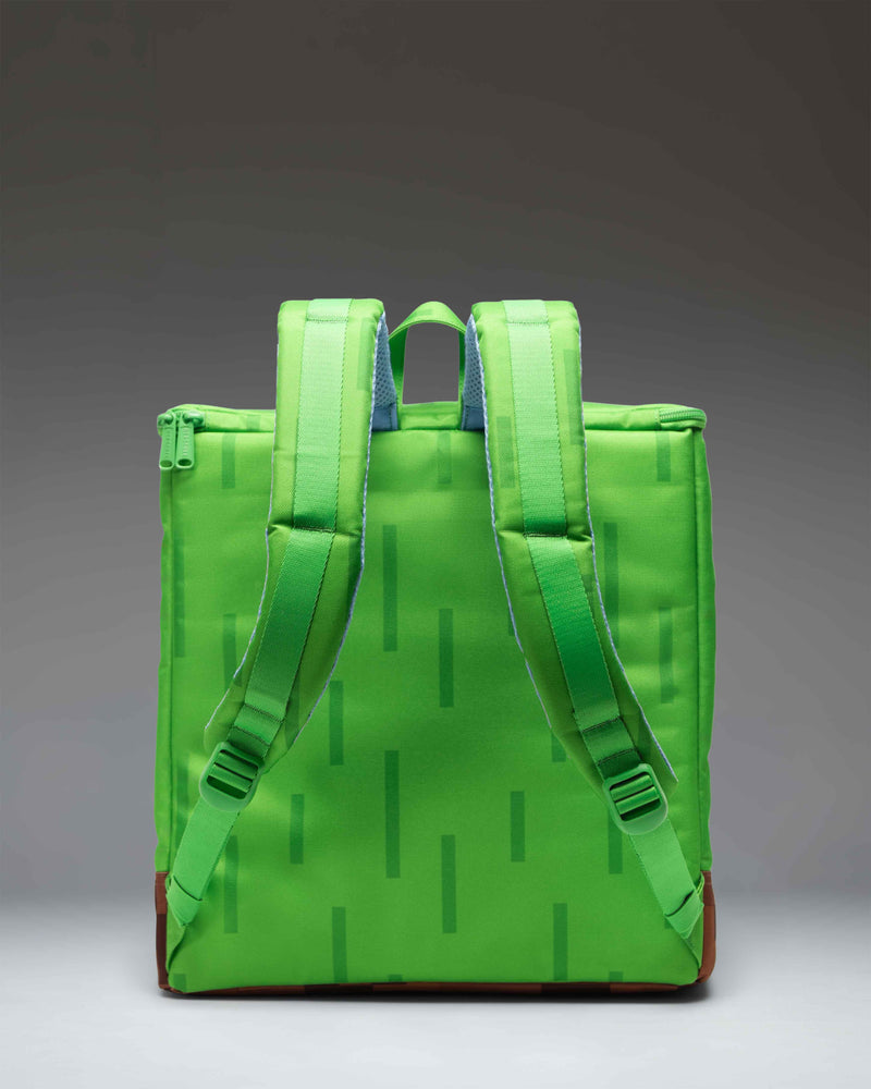 Herschel Supply Co. Minecraft Cube Backpack in Grass Block color showing the pixelated green and brown design with a front zippered pocket.