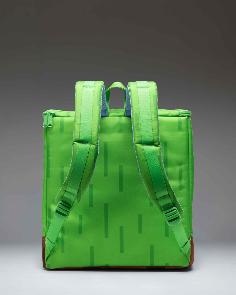 Herschel Supply Co. Minecraft Cube Backpack in Grass Block color showing the pixelated green and brown design with a front zippered pocket.