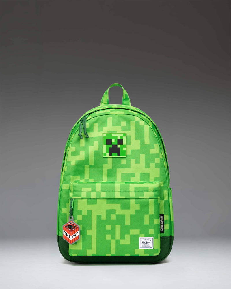 Herschel Supply Co. Minecraft Heritage youth backpack featuring the iconic pixelated green Creeper pattern.