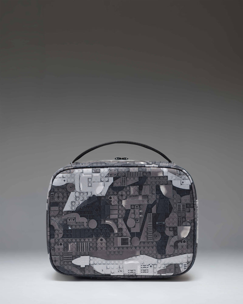 Herschel Supply Co. LEGO Pop Quiz Lunch Box in Abstract Bricks Black, showing the insulated interior and front zippered pocket.