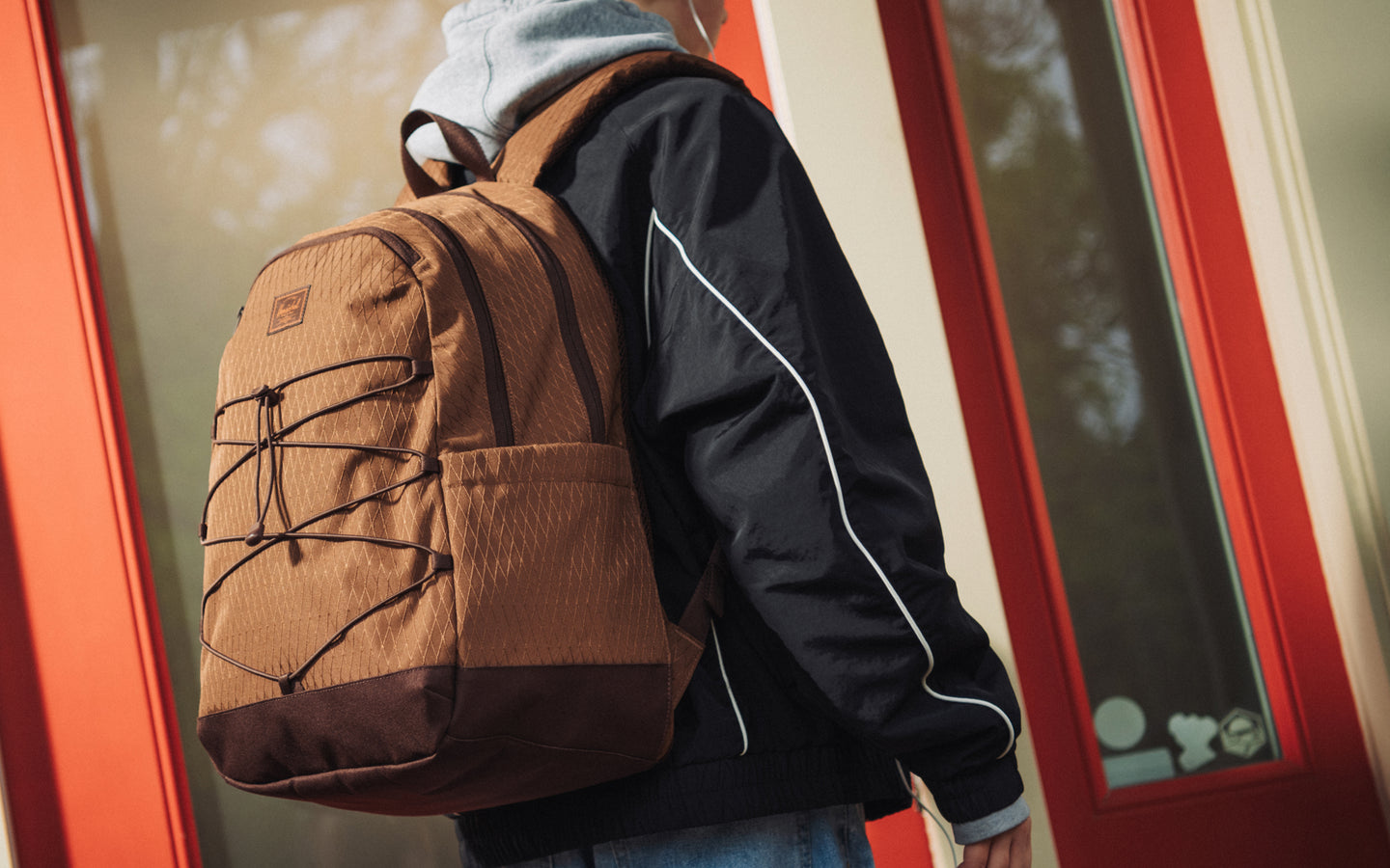 Herschel Kingston Backpack in Soft Silt Diamond and Chicory Coffee with a sporty silhouette, front bungee cord system, and knotted cord pulls.