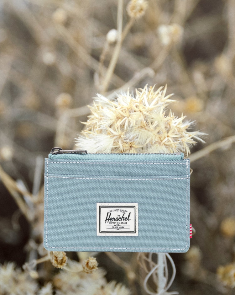 Herschel Supply Co. Oscar cardholder wallet featuring external card slots and a zippered main compartment.