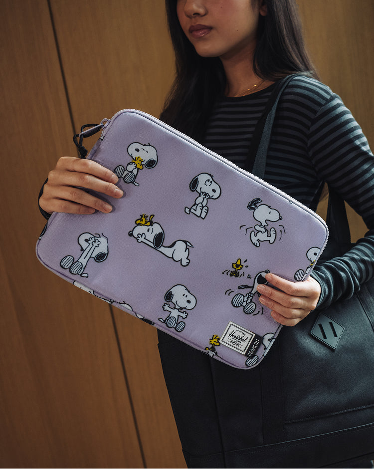 Herschel Supply Co. Peanuts Anchor 14 Inch Sleeve in Snoopy and Woodstock Pastel Lilac.